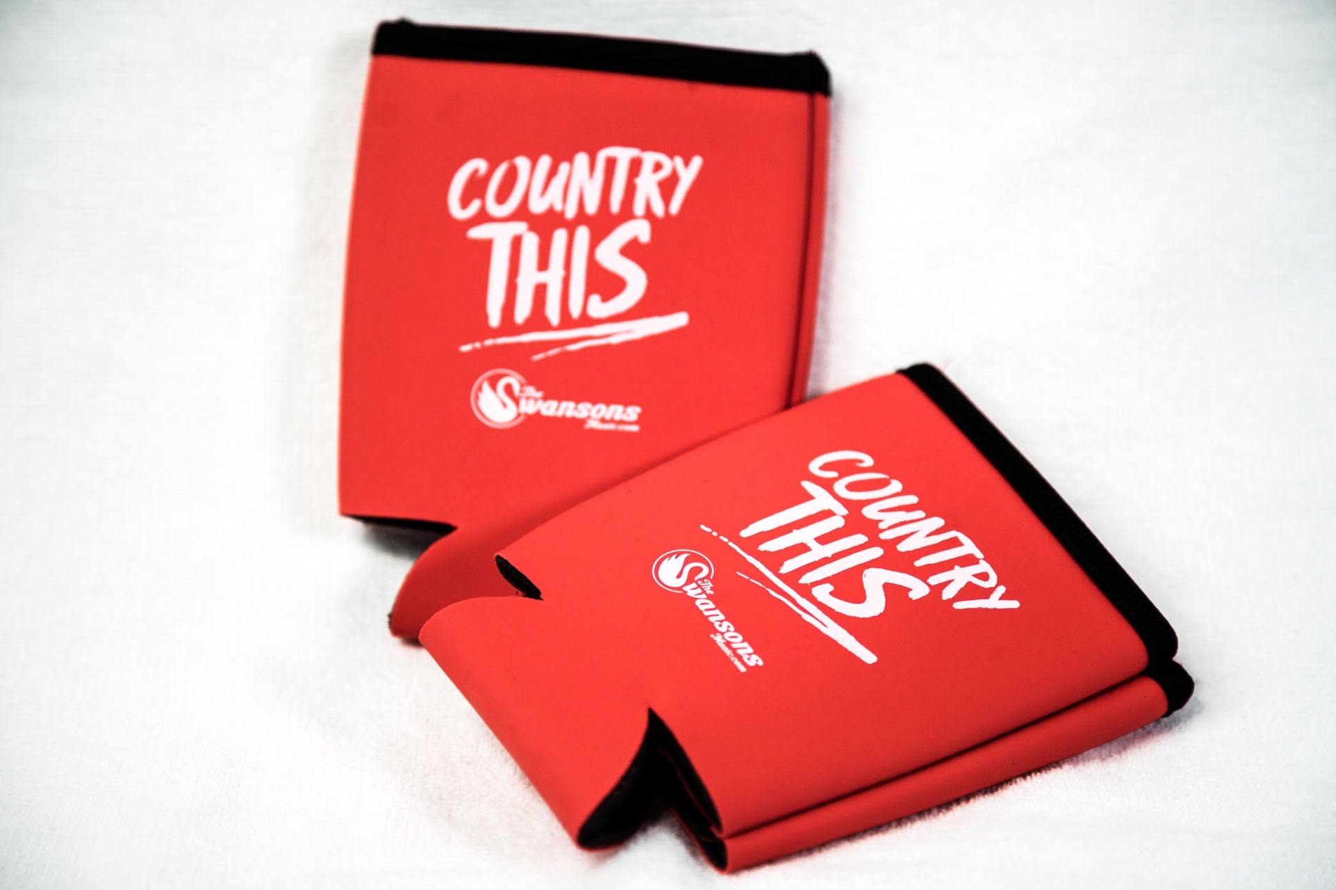 Two red can coolers with the word country this on them.