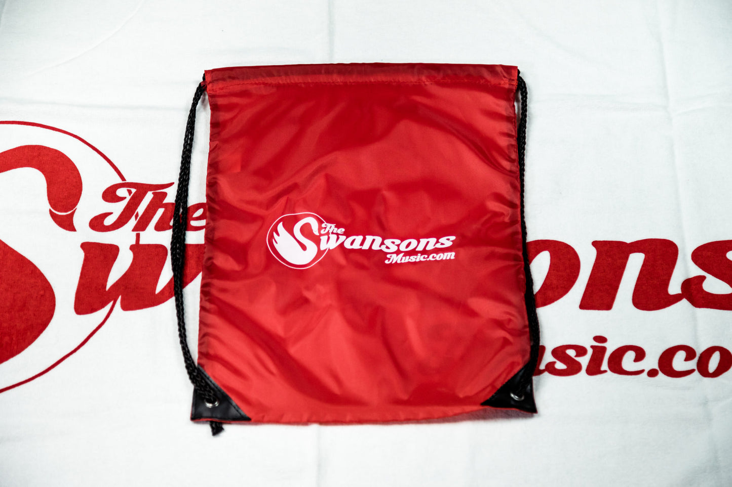 A red drawsack bag with a logo on it.