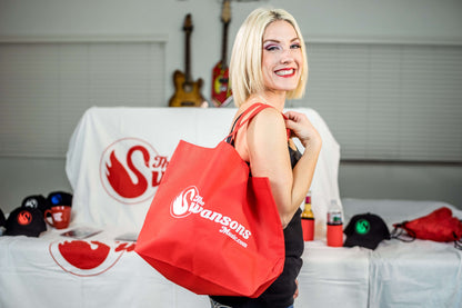 A blonde woman holding a red tote bag.