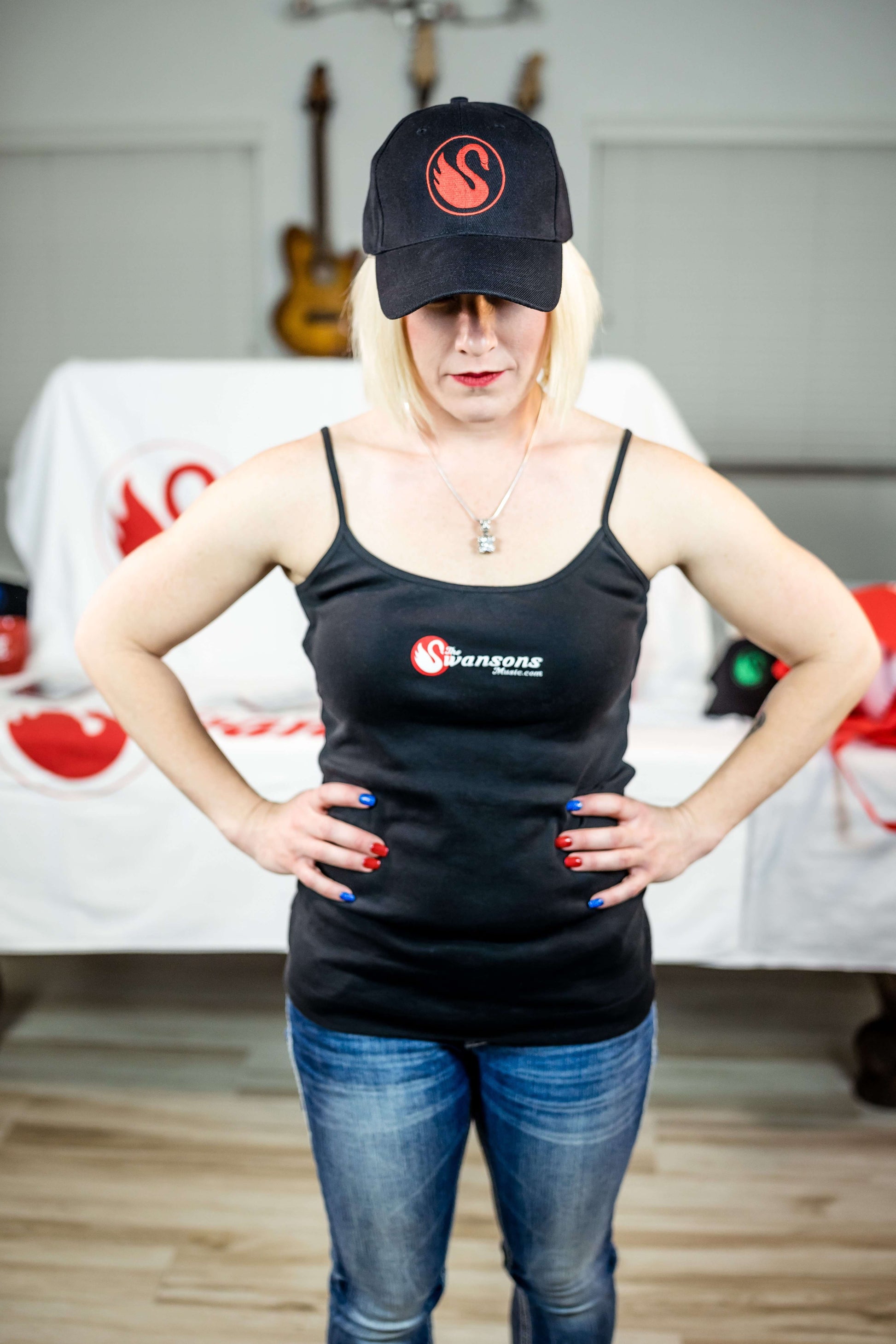 A woman wearing a black tank top and hat.