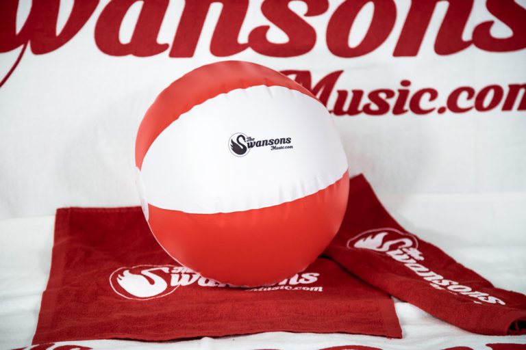 A red and white beach ball with a towel on it.