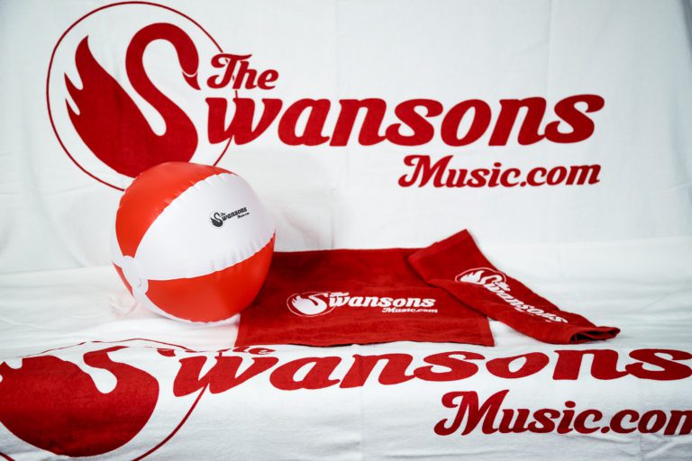 The swansons music logo on a towel and a beach ball.