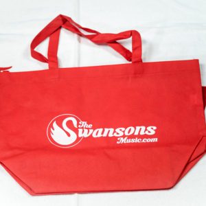 A red tote bag with the swansons logo on it.