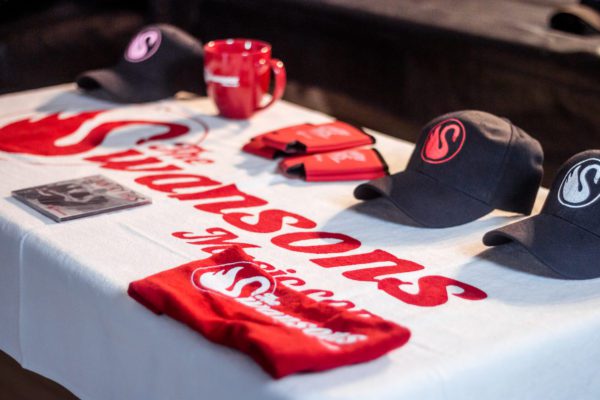 A table with hats and shirts on it.