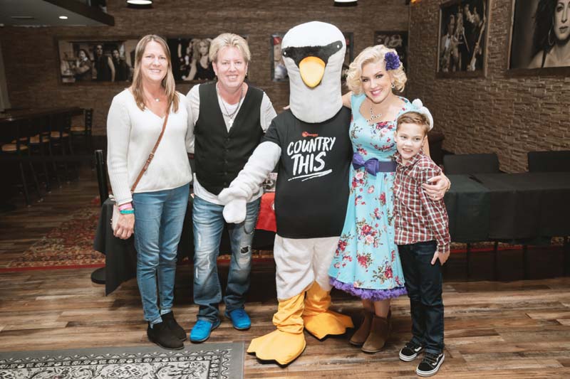 A group of people posing with a mascot.