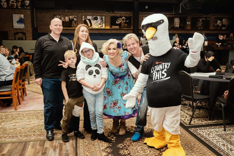 A group of people posing for a photo with a mascot.