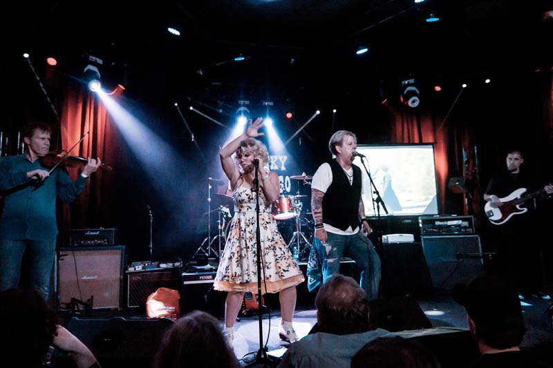 A group of people singing on stage at a concert.