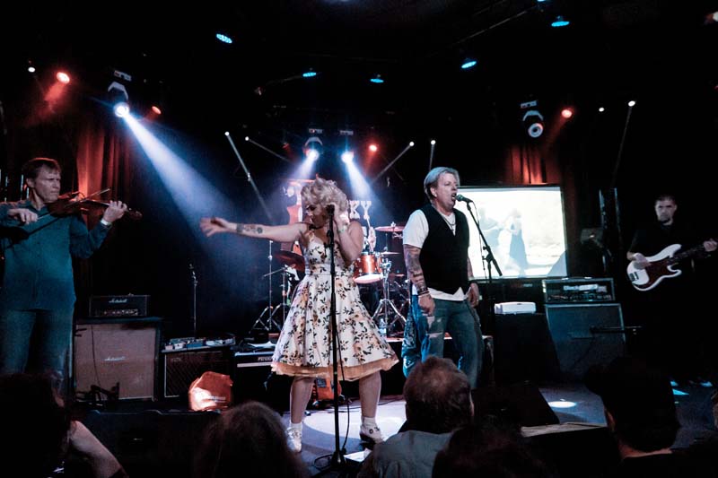 A group of people singing on stage at a concert.