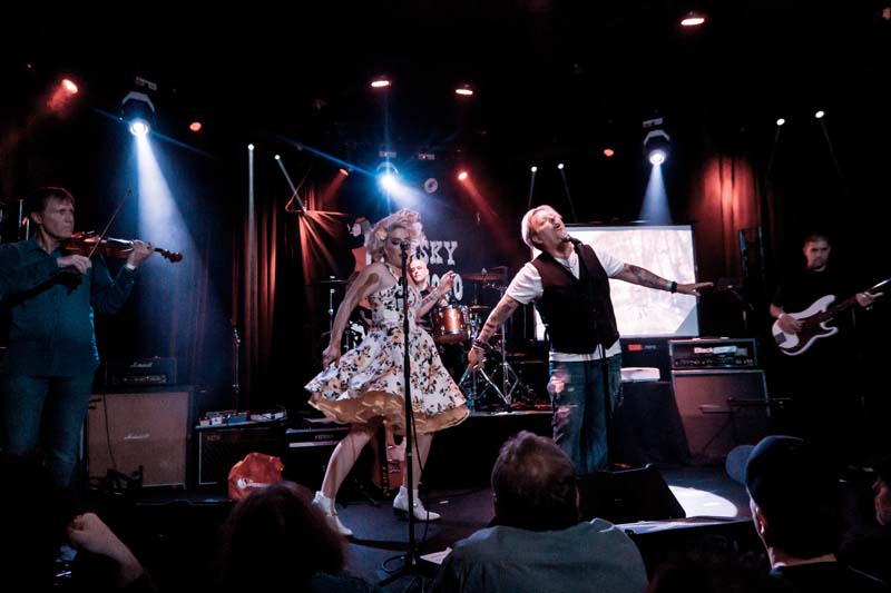 A group of people performing on stage in front of a crowd.