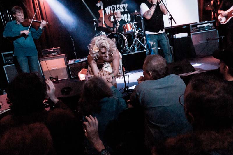 A group of people on stage with a band.