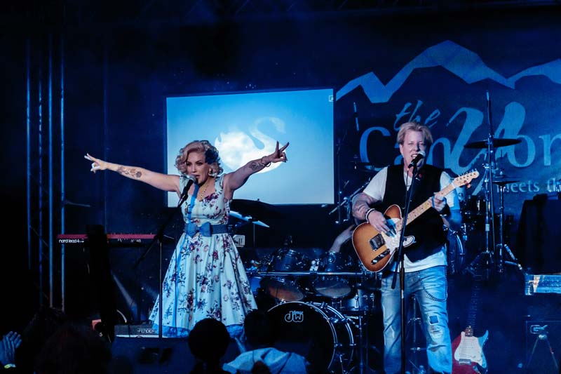 A man and woman singing on stage at a concert.