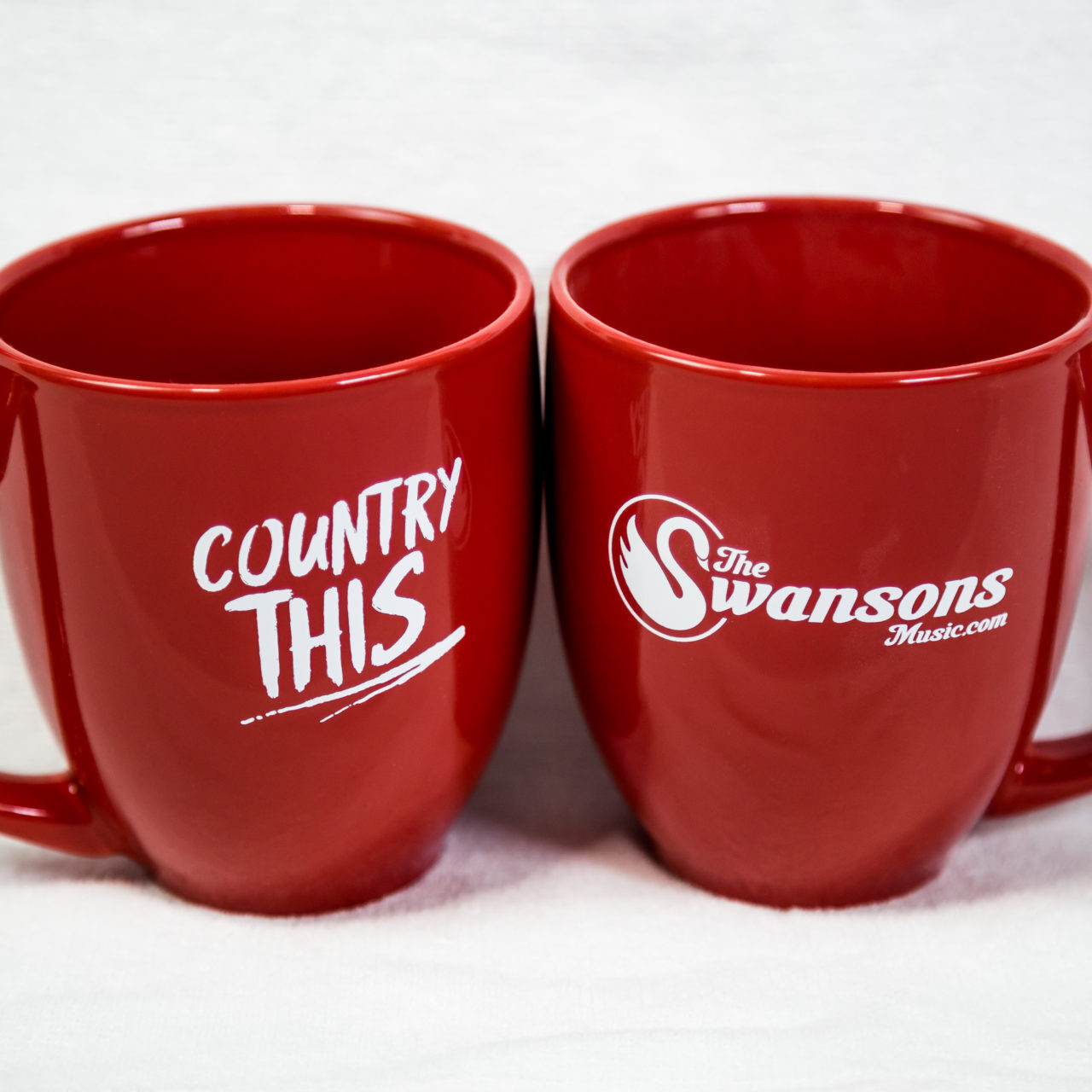 Two red mugs with the word country this on them.